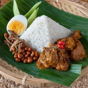 Nasi lemak beef rendang with coconut rice, tender beef rendang, boiled egg, peanuts and fried anchovies on banana leaf