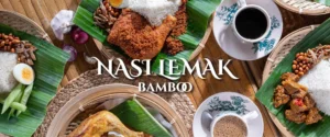 Malaysian nasi lemak bamboo presentation with fried chicken, rice, nuts, and traditional coffee service setup